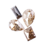 Natural brown salt and pepper diamond set featuring two pear shaped diamonds and two baguette step cut diamonds with visible natural inclusions and rustic champagne tones for custom jewelry design.
