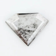 Shield cut lab grown diamond with clear body and natural-looking black inclusions in a salt and pepper pattern, faceted loose gemstone for custom jewelry