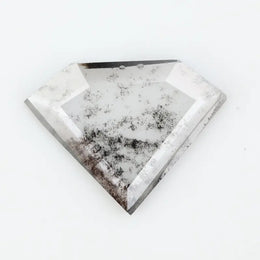 Shield cut lab grown diamond with clear body and natural-looking black inclusions in a salt and pepper pattern, faceted loose gemstone for custom jewelry