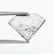 Shield cut lab grown diamond with clear body and natural-looking black inclusions in a salt and pepper pattern, faceted loose gemstone for custom jewelry