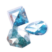 Collection of natural blue diamonds in unique geometric cuts including triangular, hexagon, and pear shapes with vivid ocean-blue tones and natural inclusions on a white background.