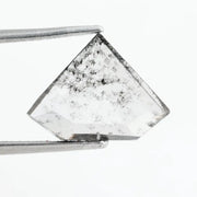 Shield cut lab grown diamond with clear body and natural-looking black inclusions in a salt and pepper pattern, faceted loose gemstone for custom jewelry