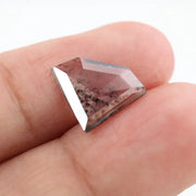 Shield cut lab grown diamond with clear body and natural-looking black inclusions in a salt and pepper pattern, faceted loose gemstone for custom jewelry