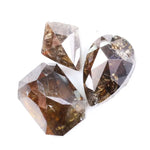 Three natural brown diamonds with unique cuts and facets, showcasing a rich, earthy hue and natural inclusions, perfect for fine jewelry or collectors.