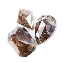 Three natural brown diamonds with unique cuts and facets, showcasing a rich, earthy hue and natural inclusions, perfect for fine jewelry or collectors.