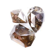 Three natural brown diamonds with unique cuts and facets, showcasing a rich, earthy hue and natural inclusions, perfect for fine jewelry or collectors.