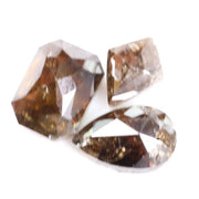 Three natural brown diamonds with unique cuts and facets, showcasing a rich, earthy hue and natural inclusions, perfect for fine jewelry or collectors.