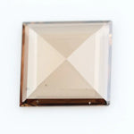 Square pyramid cut lab grown diamond with soft champagne tone, high clarity, polished facets, and modern geometric shape on a clean white background