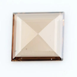 Square pyramid cut lab grown diamond with soft champagne tone, high clarity, polished facets, and modern geometric shape on a clean white background