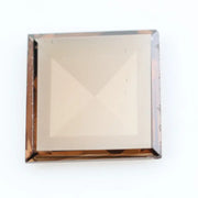 Square pyramid cut lab grown diamond with soft champagne tone, high clarity, polished facets, and modern geometric shape on a clean white background