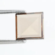 Square pyramid cut lab grown diamond with soft champagne tone, high clarity, polished facets, and modern geometric shape on a clean white background
