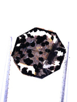 Polished lab grown diamond on a stand against a white background