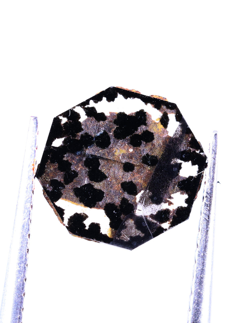 Polished lab grown diamond on a stand against a white background