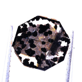 Polished lab grown diamond on a stand against a white background