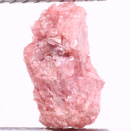Raw pink light pink on tweezers against a white background