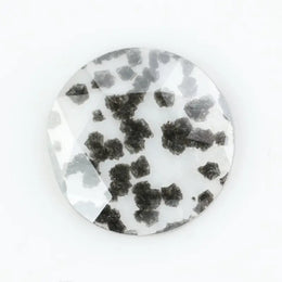 Round faceted lab grown diamond with distinctive black inclusions creating a salt and pepper effect inside a clear polished gemstone