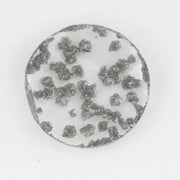 Round faceted lab grown diamond with distinctive black inclusions creating a salt and pepper effect inside a clear polished gemstone