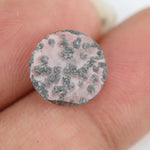 Round faceted lab grown diamond with distinctive black inclusions creating a salt and pepper effect inside a clear polished gemstone