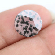 Round faceted lab grown diamond with distinctive black inclusions creating a salt and pepper effect inside a clear polished gemstone