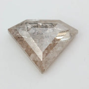 Close-up of a faceted lab grown diamond with visible natural-style inclusions, brilliant cut geometry, and soft champagne hue on a clean white background