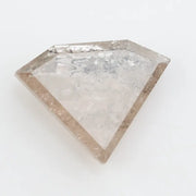 Close-up of a faceted lab grown diamond with visible natural-style inclusions, brilliant cut geometry, and soft champagne hue on a clean white background