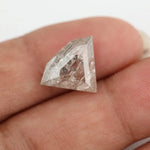 Close-up of a faceted lab grown diamond with visible natural-style inclusions, brilliant cut geometry, and soft champagne hue on a clean white background