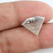 Close-up of a faceted lab grown diamond with visible natural-style inclusions, brilliant cut geometry, and soft champagne hue on a clean white background