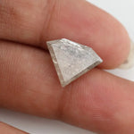 Close-up of a faceted lab grown diamond with visible natural-style inclusions, brilliant cut geometry, and soft champagne hue on a clean white background