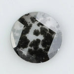 Round cut lab grown salt and pepper diamond featuring bold black dendritic inclusions in a transparent stone, faceted for brilliance and showcasing a unique natural pattern