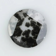 Round cut lab grown salt and pepper diamond featuring bold black dendritic inclusions in a transparent stone, faceted for brilliance and showcasing a unique natural pattern