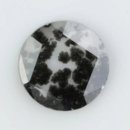 Round cut lab grown salt and pepper diamond featuring bold black dendritic inclusions in a transparent stone, faceted for brilliance and showcasing a unique natural pattern