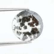 Round cut lab grown salt and pepper diamond featuring bold black dendritic inclusions in a transparent stone, faceted for brilliance and showcasing a unique natural pattern