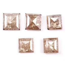 Five square step cut champagne lab grown diamonds with galaxy salt and pepper inclusions, pyramid faceting, and rustic brown tones displayed on a white background.