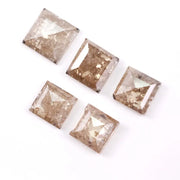Five square step cut champagne lab grown diamonds with galaxy salt and pepper inclusions, pyramid faceting, and rustic brown tones displayed on a white background.