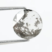 Round faceted lab grown diamond with distinctive salt and pepper style inclusions creating a galaxy-like pattern, showcasing a unique and modern alternative to traditional clear diamonds