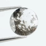 Round faceted lab grown diamond with distinctive salt and pepper style inclusions creating a galaxy-like pattern, showcasing a unique and modern alternative to traditional clear diamonds