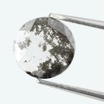 Round faceted lab grown diamond with distinctive salt and pepper style inclusions creating a galaxy-like pattern, showcasing a unique and modern alternative to traditional clear diamonds