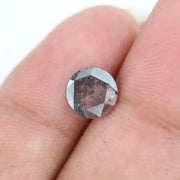 Round faceted lab grown diamond with distinctive salt and pepper style inclusions creating a galaxy-like pattern, showcasing a unique and modern alternative to traditional clear diamonds