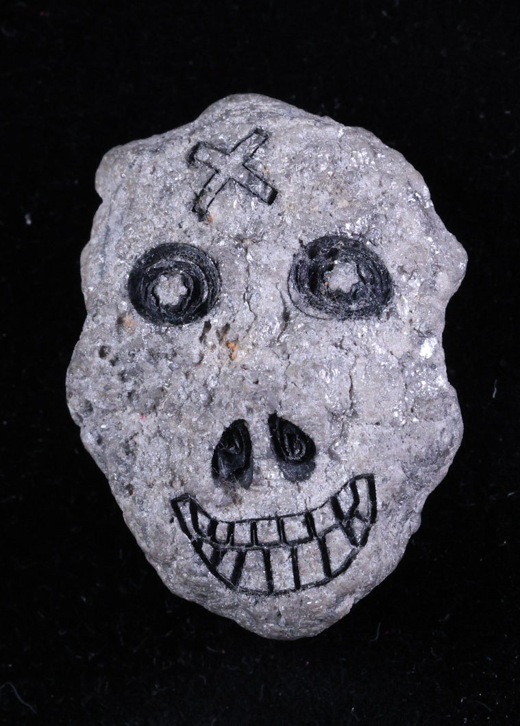 Decorative stone with skull design on a black background