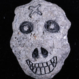 Decorative stone with skull design on a black background
