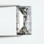 Rectangular step cut lab grown diamond featuring bold black salt and pepper inclusions with mirror-like facets and a modern geometric shape