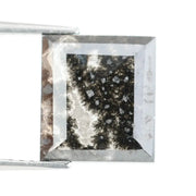 Rectangular step cut salt and pepper lab grown diamond with black galaxy inclusions and scattered white speckles, unique ethical diamond for custom jewelry design