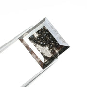 Rectangular step cut salt and pepper lab grown diamond with black galaxy inclusions and scattered white speckles, unique ethical diamond for custom jewelry design