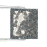 Rectangular step cut salt and pepper lab grown diamond with black galaxy inclusions and scattered white speckles, unique ethical diamond for custom jewelry design