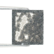 Rectangular step cut salt and pepper lab grown diamond with black galaxy inclusions and scattered white speckles, unique ethical diamond for custom jewelry design