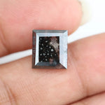 Rectangular step cut salt and pepper lab grown diamond with black galaxy inclusions and scattered white speckles, unique ethical diamond for custom jewelry design