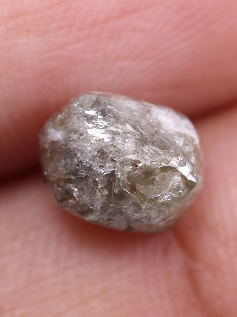 Raw diamond held between fingers