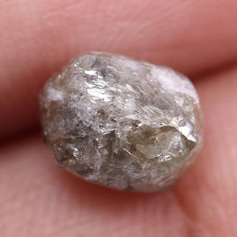 Raw diamond held between fingers