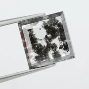 Geometric step cut lab grown salt and pepper diamond with black moss-like inclusions, clear edges and modern faceting, unique ethical loose diamond for alternative engagement ring