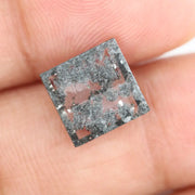 Geometric step cut lab grown salt and pepper diamond with black moss-like inclusions, clear edges and modern faceting, unique ethical loose diamond for alternative engagement ring